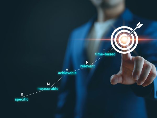 Businessman pointing at a target illustrating SMART goals concept.