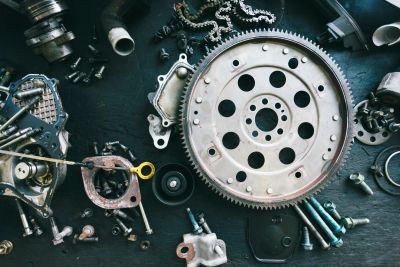 Various mechanical parts and tools arranged on a dark surface.