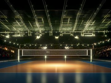Indoor volleyball court brightly lit with an empty net and audience seating.