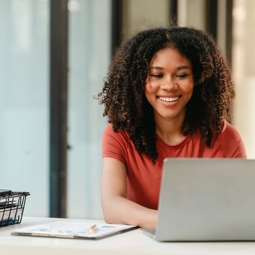 Smiling woman working on laptop.