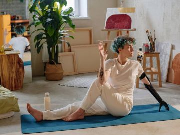Person with prosthetic arm doing yoga indoors.