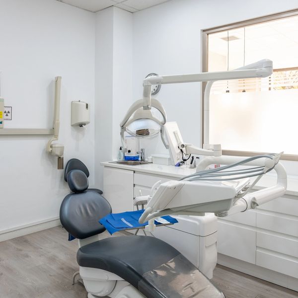 Modern dental clinic room with a dental chair and equipment.