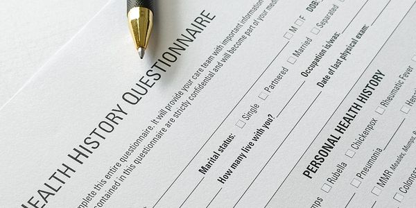 Close-up of a health history questionnaire form with a pen.