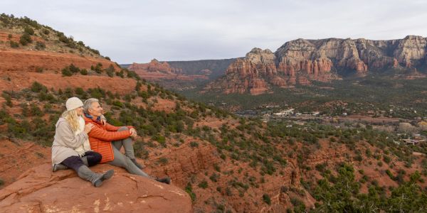 Couple enjoying a scenic view on red rocks.
