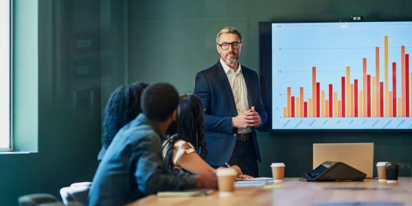 Businessman presenting data on a screen to colleagues.