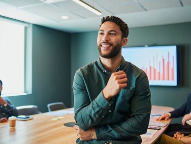 Confident gentleman smiling in business meeting room