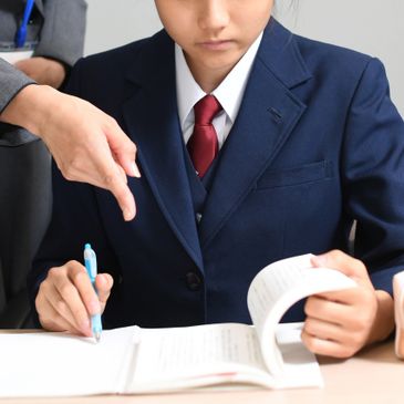 Student in uniform being guided while studying.