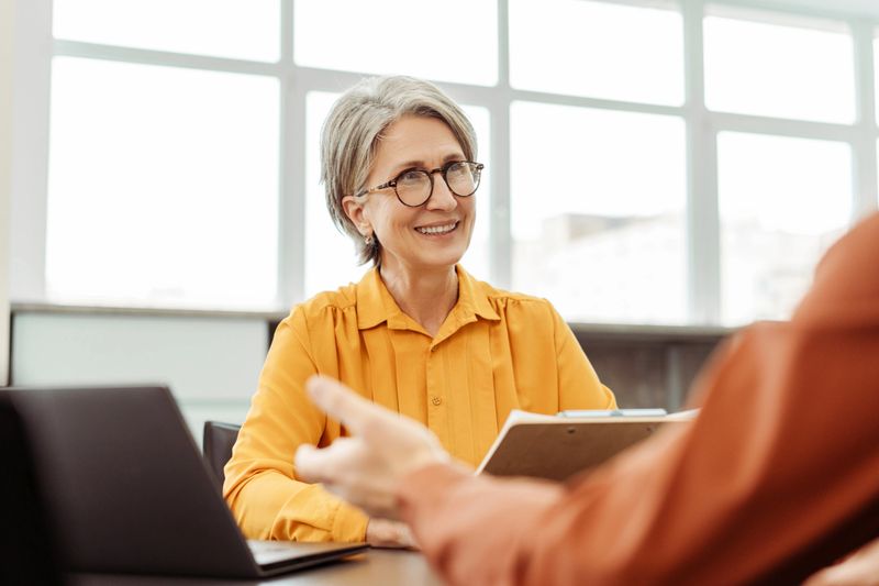 Senior and fitness trainer having a friendly consultation conversation at home