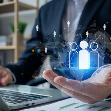 Businessman presenting digital people icons over a laptop keyboard.