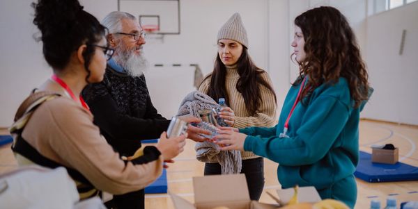 Volunteers distributing supplies in a community gym.