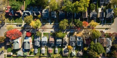 Aerial view of a suburban neighborhood with houses and colorful trees.