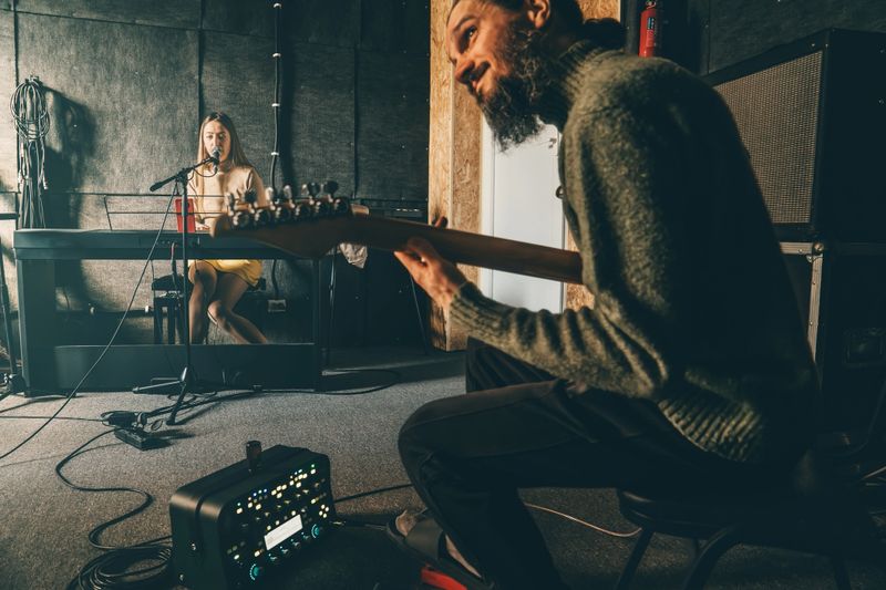 Musicians rehearsing in sound recording studio. Music band repetition.