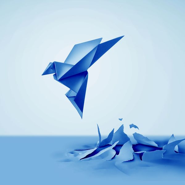 Blue paper crane bursting out of the floor and flying into the sky