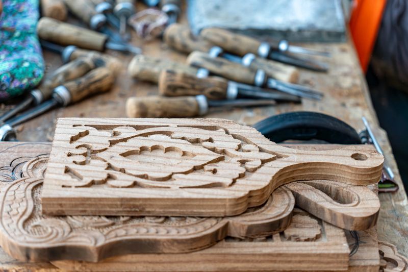 Wooden cutting boards of various shapes on the table. The ancient craft of wood carving.