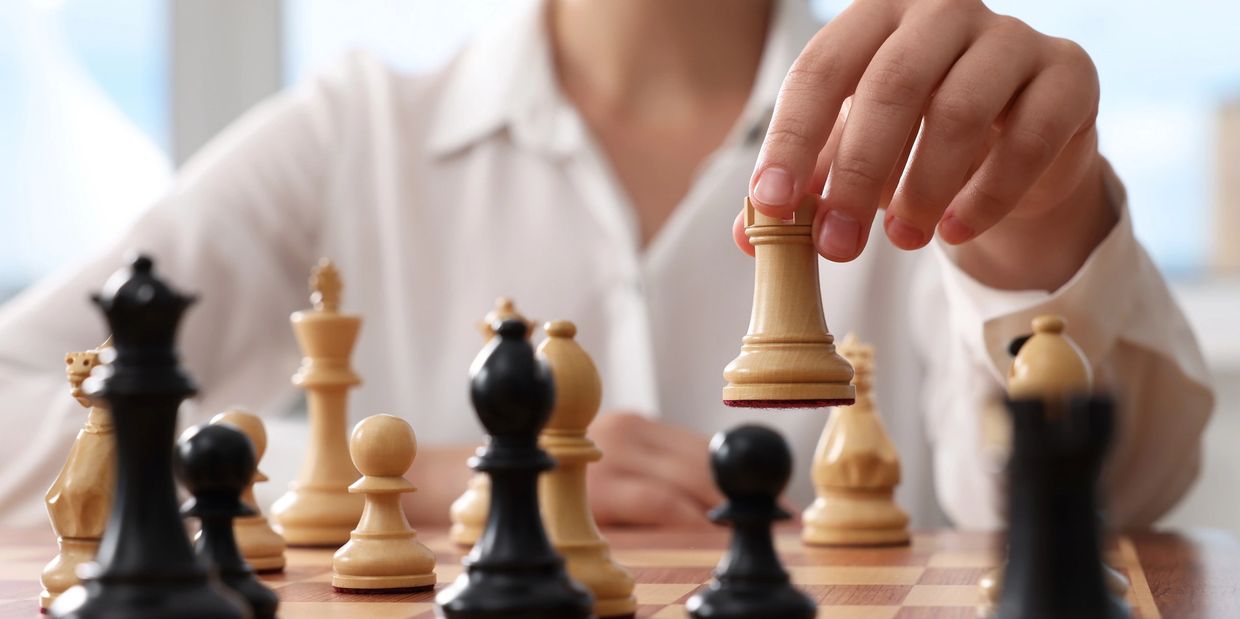 A woman holding a white rook chess piece