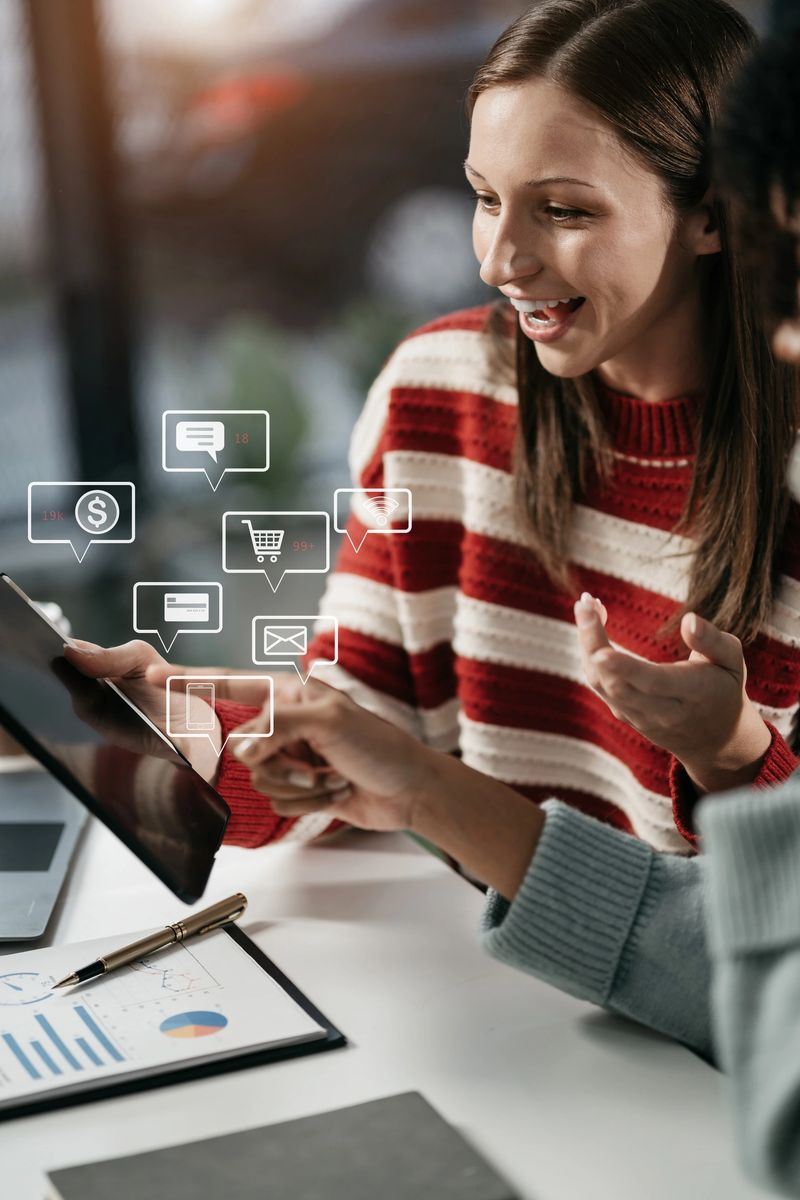 Businesswomen using tablet with laptop and document on desk in modern office with virtual interface graphic icons network diagram.