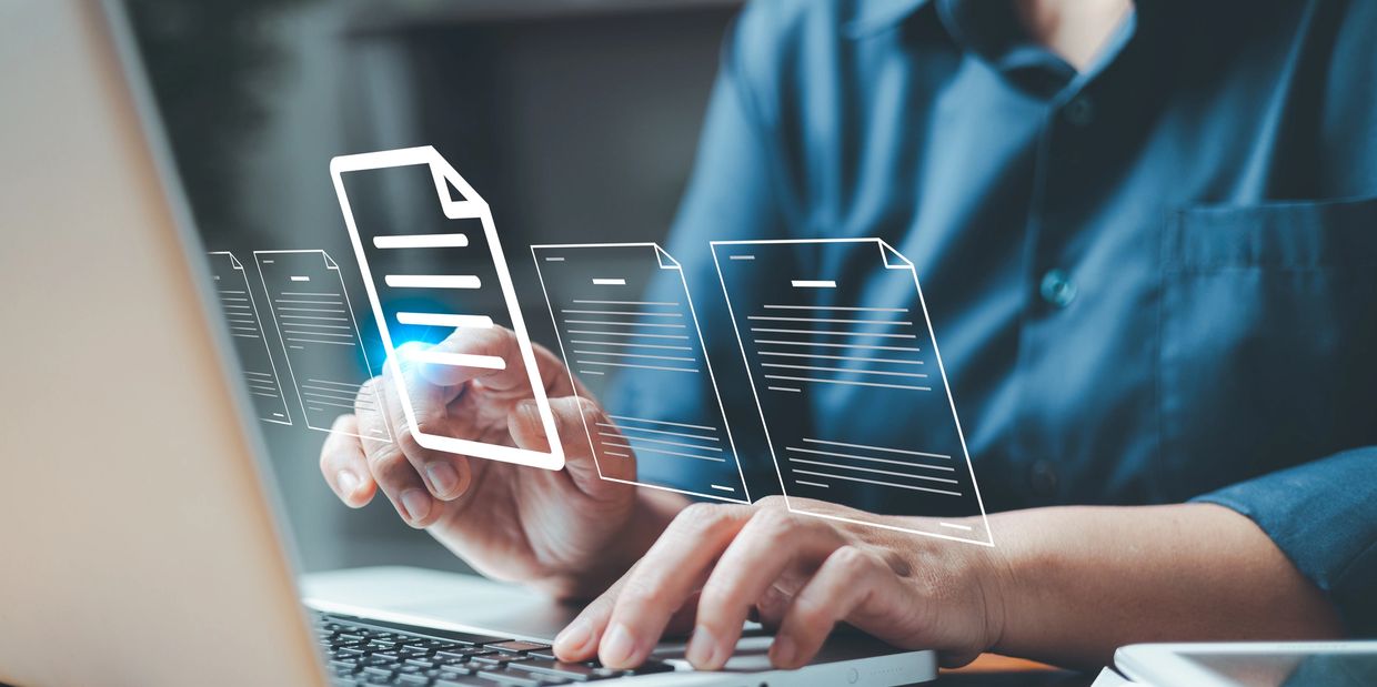 Person interacting with digital document icons above a laptop keyboard.