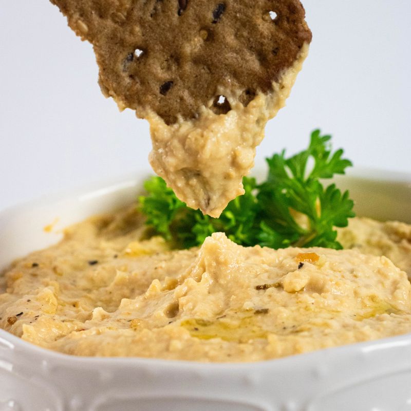 Chickpeas hummus, olive oil, raw chickpeas, close-up, a leaf of parsley light gray background. Middle eastern snacks set. Vegan, vegetarian food concept.
