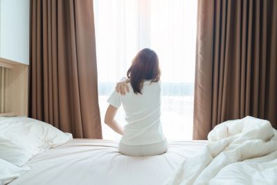 A person getting out of bed in the morning with muscle pain from fibromyalgia.