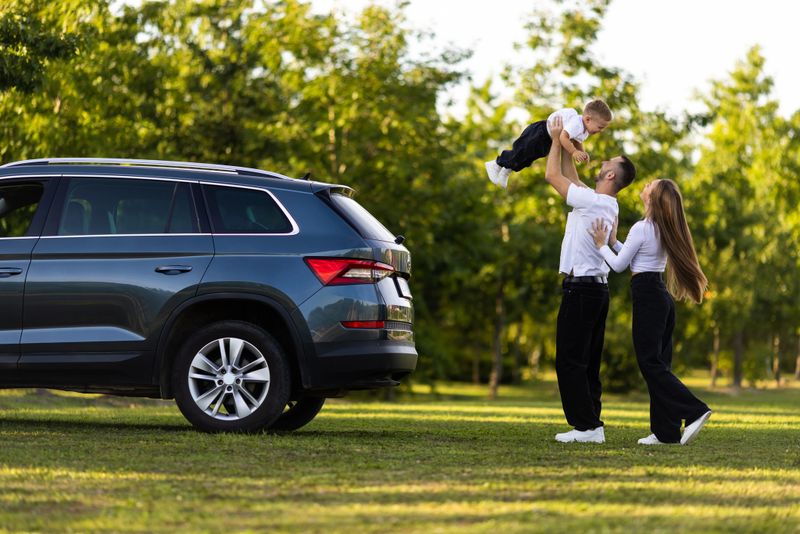 Adult couple with their little children having picnic in the Park Outside the City, Family Weekend Concept, People Enjoying Summer