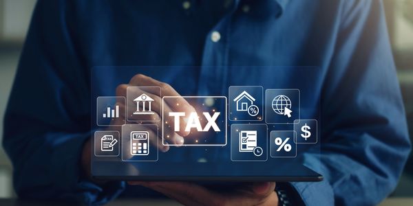 Person interacting with digital tax-related icons on a tablet.
