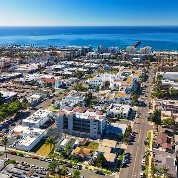 Aerial view of a coastal city with buildings and ocean in the background.