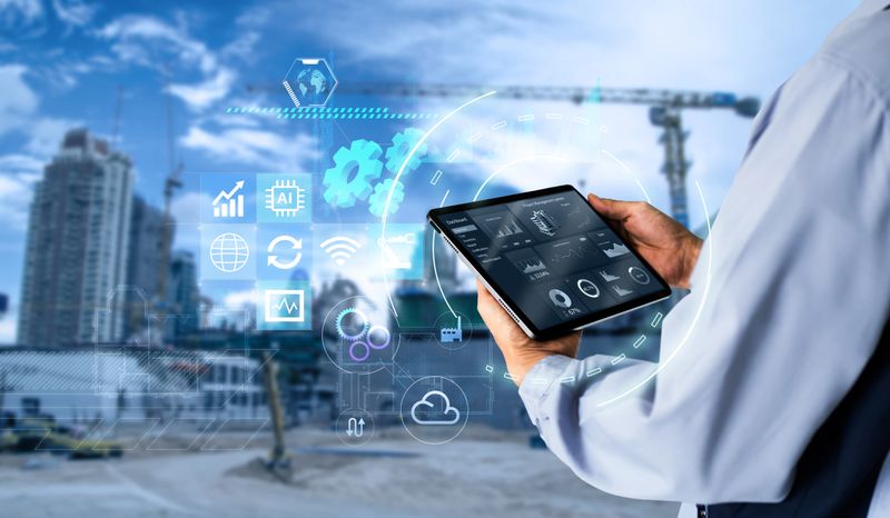 Hands using digital tablet with Construction Management Software on blurred construction site as background