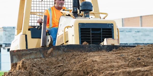Man operating a bulldozer at a construction site.