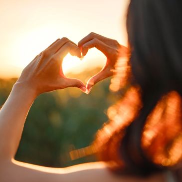 Woman's hands placed together in a heart shape.