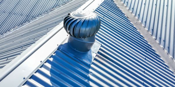 Metal roof with a ventilator under sunlight.