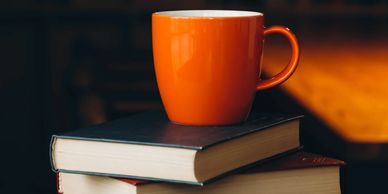 A cup standing of top of four books