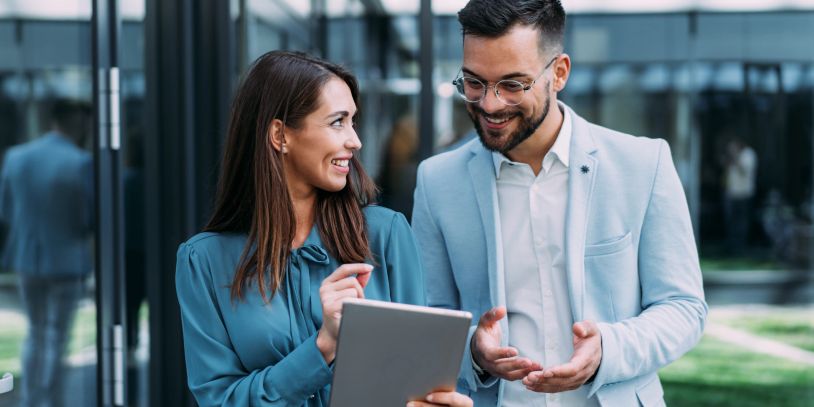 Two professionals discussing work on a tablet.