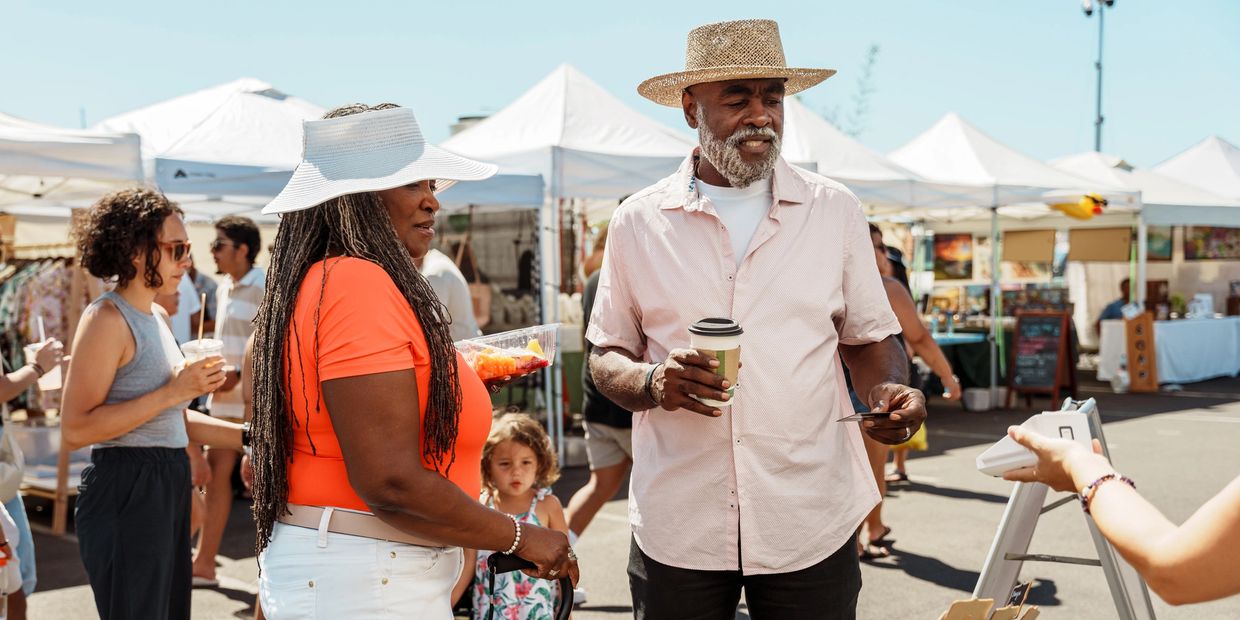 Senior couple shopping at outdoor market.