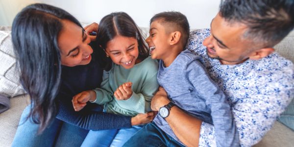 A joyful family laughing together on a couch.