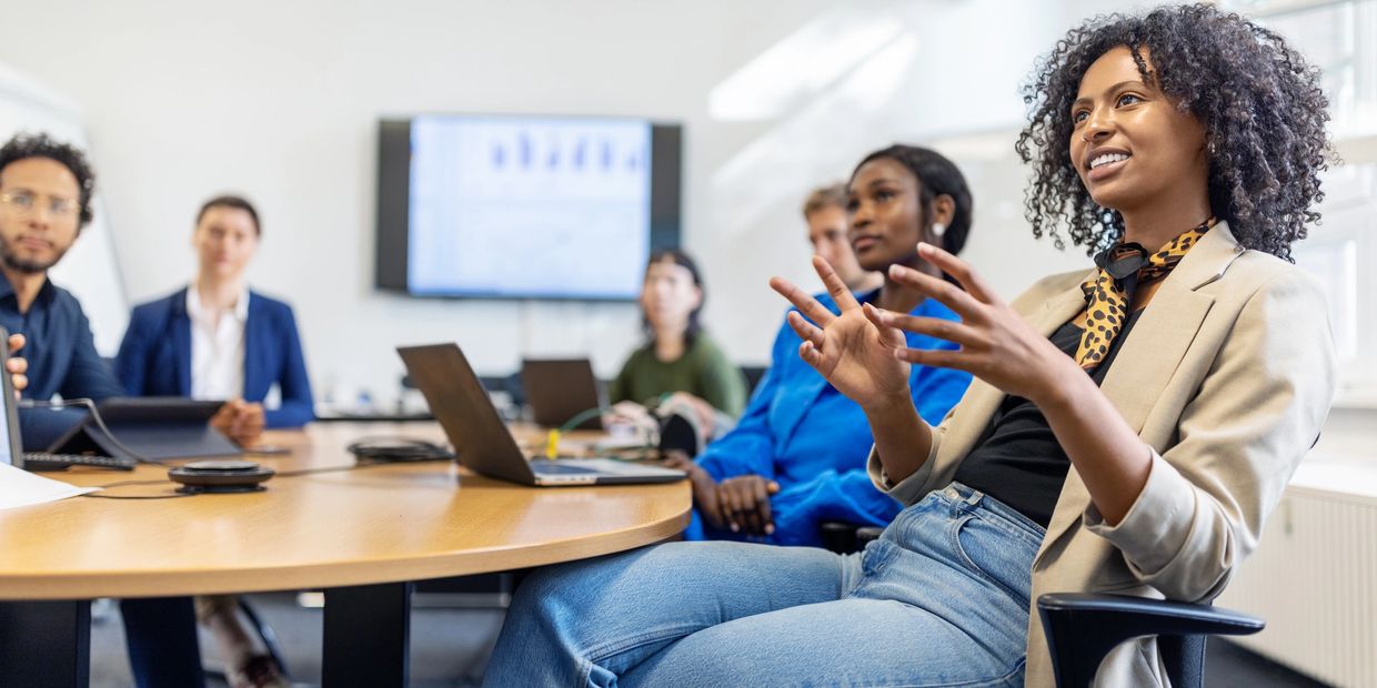 A woman leads a discussion in a modern office meeting.