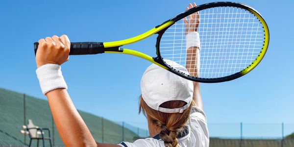 Tennis player ready to serve on a sunny day outdoors.