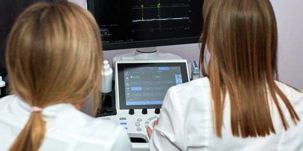 Two medical professionals operating ultrasound equipment.