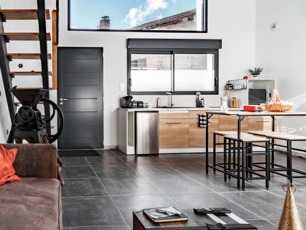 Modern open-plan kitchen and living area with sleek industrial design.