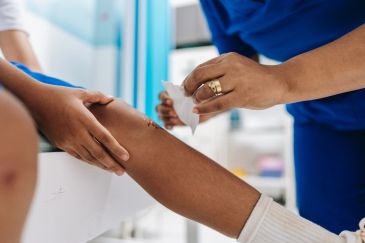 Medical professional treating a knee wound.