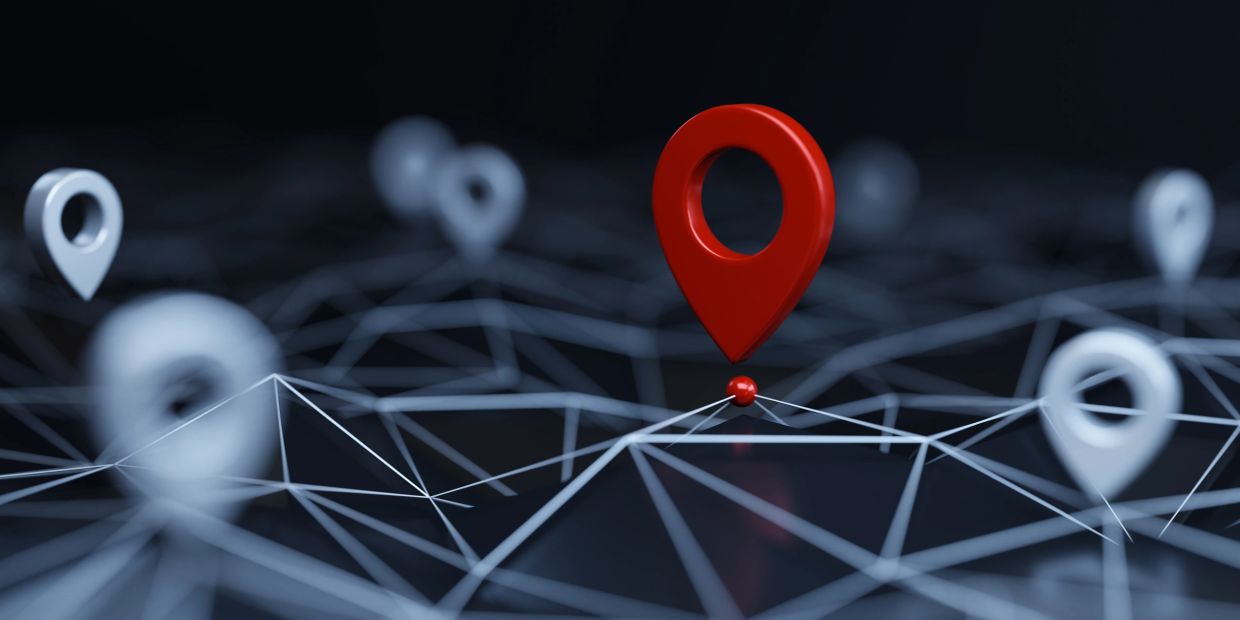 Red location pin standing out among white pins on a network.