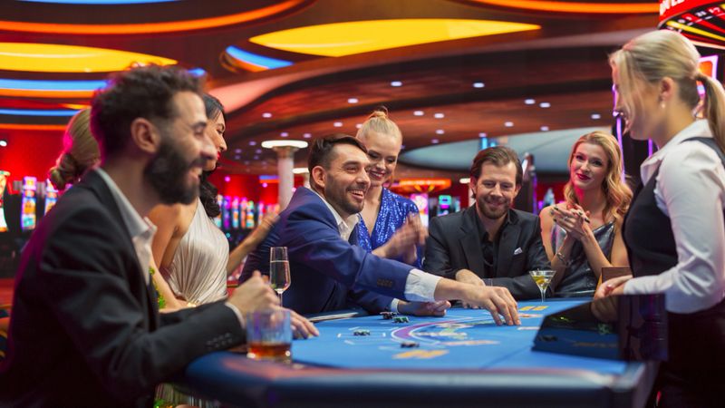 Group of Casino Goers Enjoying Time in a Modern Casino, Friends Placing Blackjack Bets, Professional Female Croupier Deals Cards. Diverse Group People Playing, Placing Bets Winning and Celebrating