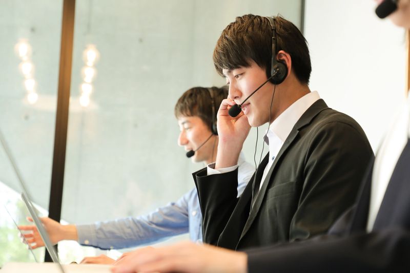 Customer service agents with headsets assisting customers over the phone.Male Customer service representatives helping to support their customers in modern office locations.