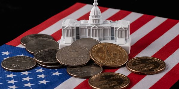 Miniature Capitol building and US coins on an American flag.