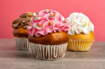 Three cupcakes with colorful frosting.