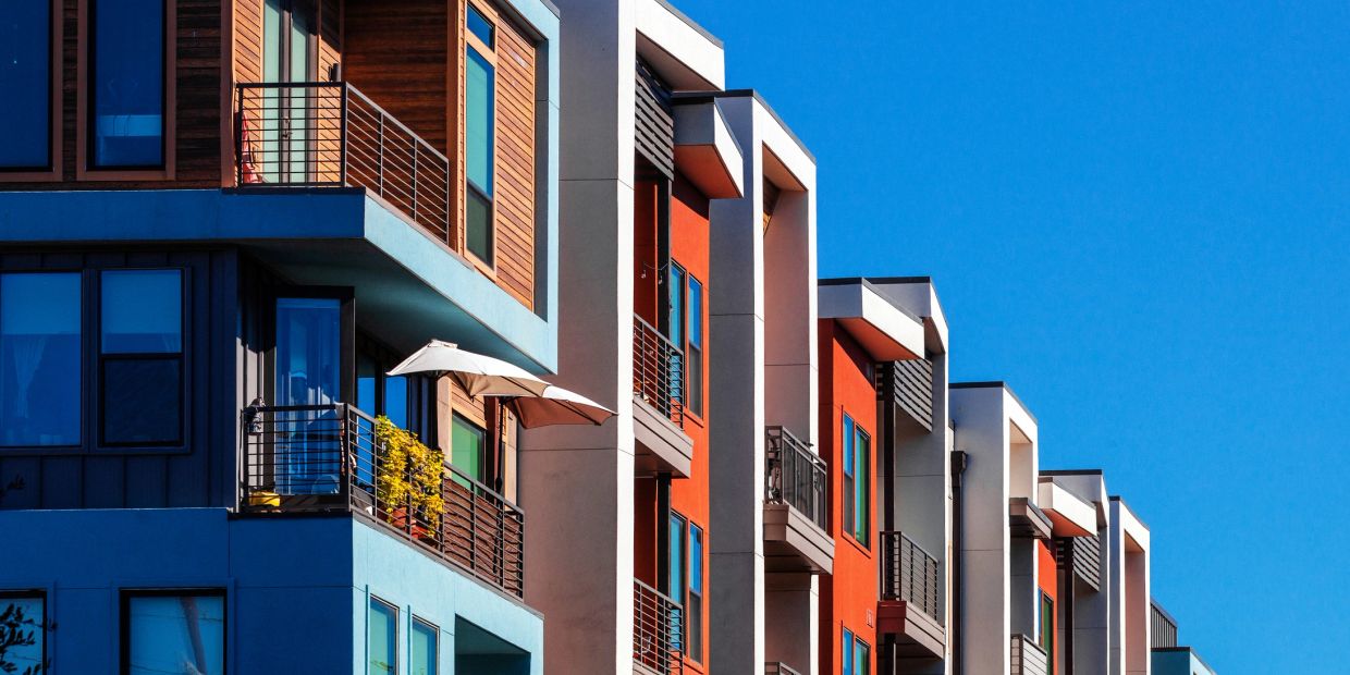 Modern colorful apartment buildings under a clear blue sky.