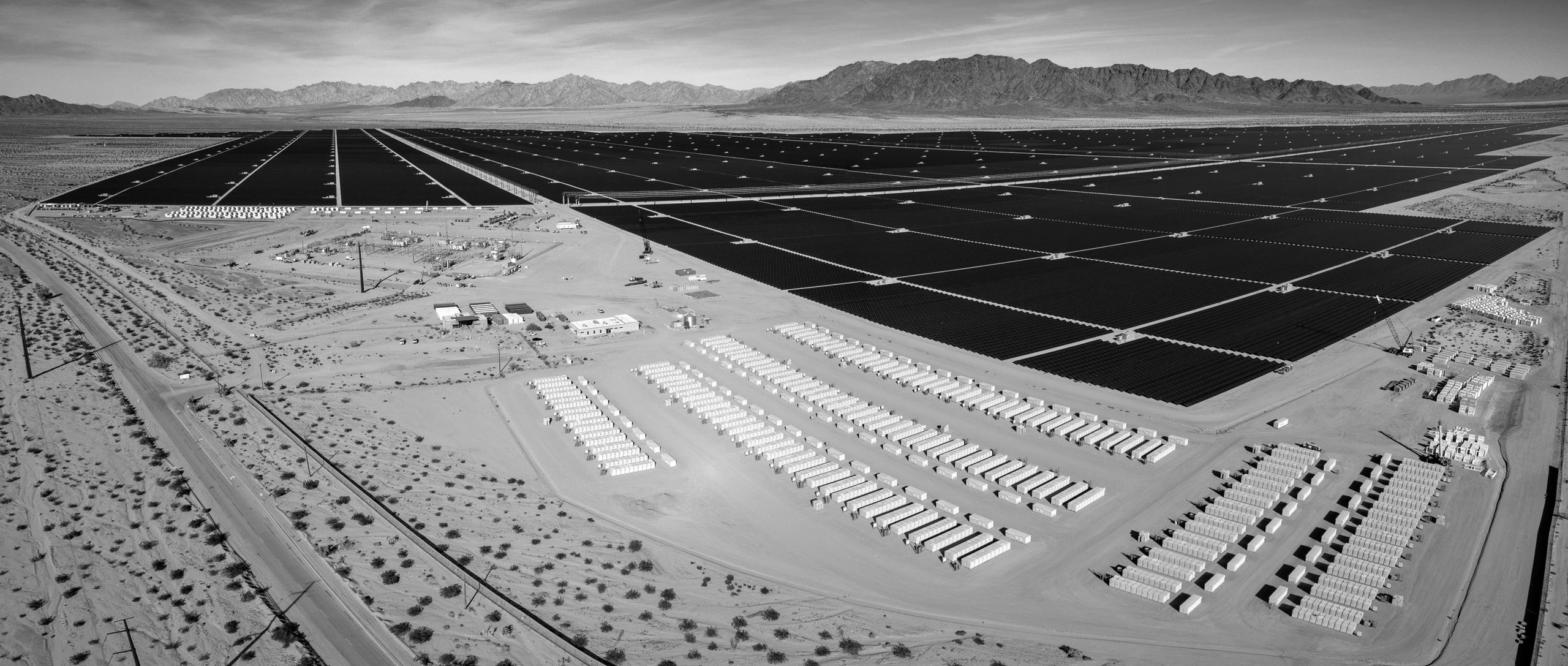 Stack of books next to pencils in a holder and a camera.