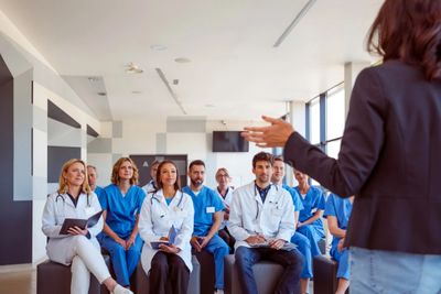 Medical professionals attending a training session led by a speaker.