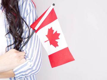 Person tenant un petit drapeau canadien.