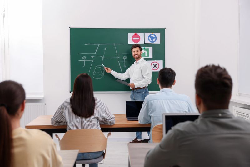Teacher explaining traffic rules to audience during lesson in driving school