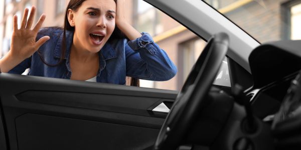 Woman upset at a car door.